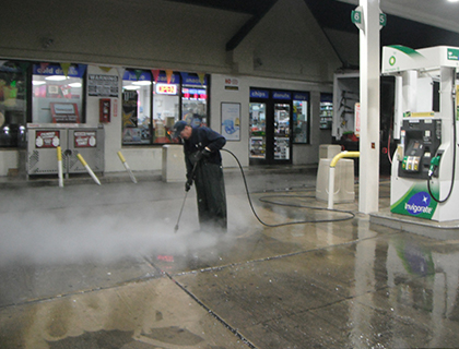 High-pressure steam cleaning a gas station apron