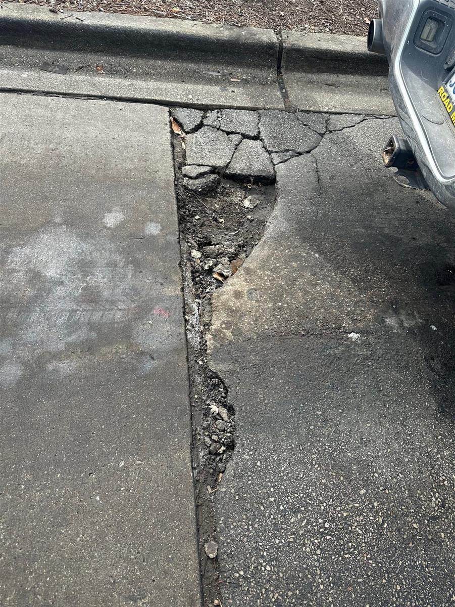 Before: Cold patch pothole repair along a curb