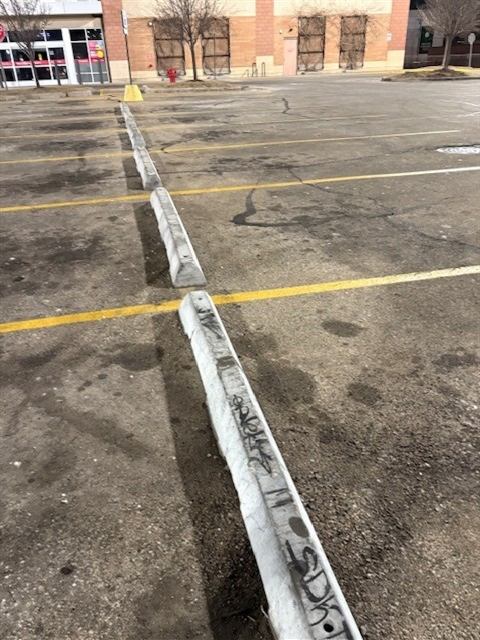 Before: Graffiti removed from parking lot curb stops