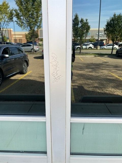 Before: Graffiti removed from a storefront door frame